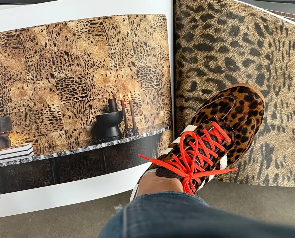 Une paire de chaussures à imprimé léopard avec des lacets rouges vifs. Les chaussures semblent être un modèle élégant et tendance, avec le motif imprimé léopard ajoutant un élément audacieux et attrayant. Les lacets rouges offrent un contraste vibrant avec les tons neutres de l'imprimé léopard, créant ainsi une composition globalement frappante et dynamique sur le plan visuel.